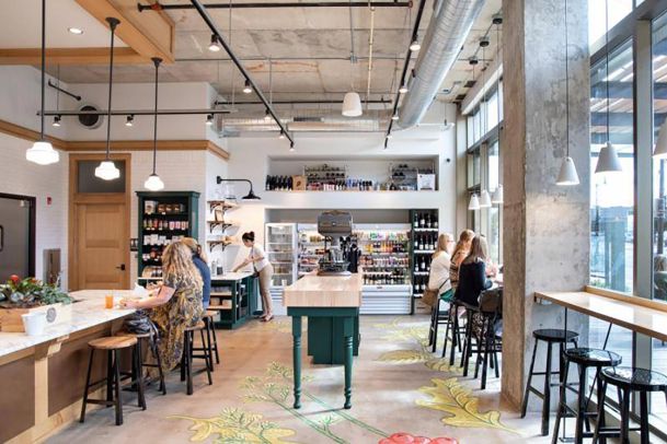 Bright cafe interior with customers seated at high-top tables and counter seating
