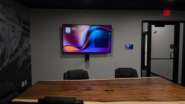 Conference room with a live-edge wooden table and wall-mounted screen