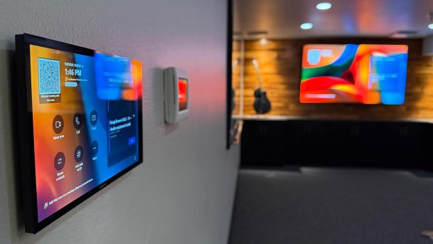 Digital smart control panel mounted on a wall near a conference room